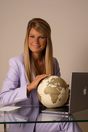 Paola Breazzano, UK Travel Specialist at UniqueBorn, with a globe at her desk