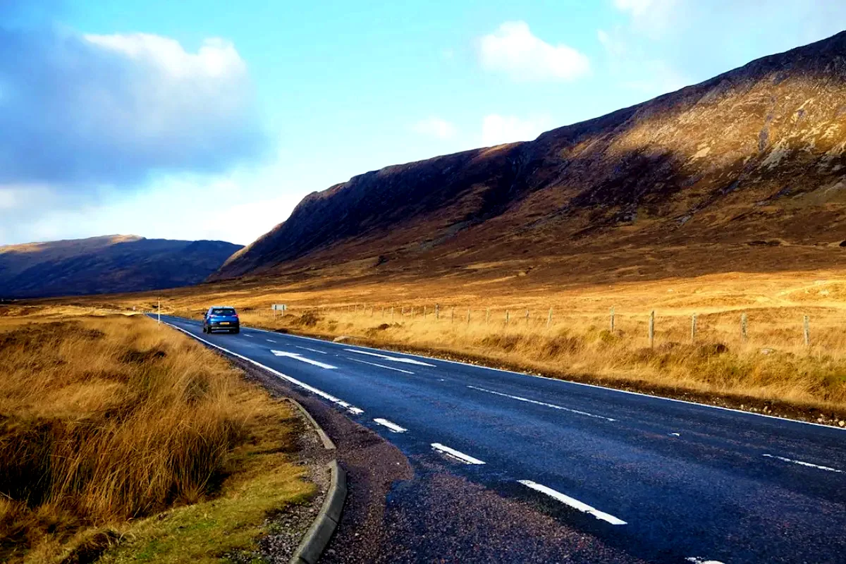 Un'auto su una strada delle Highlands scozzesi