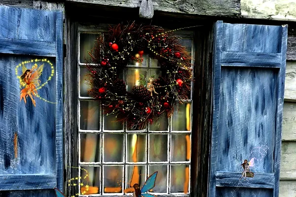 Una finestra con le persiane blu e una ghirlanda di Natale