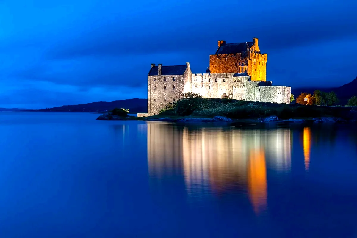 Eilean Donan Castle illuminato di sera, riflesso nel Loch Duich