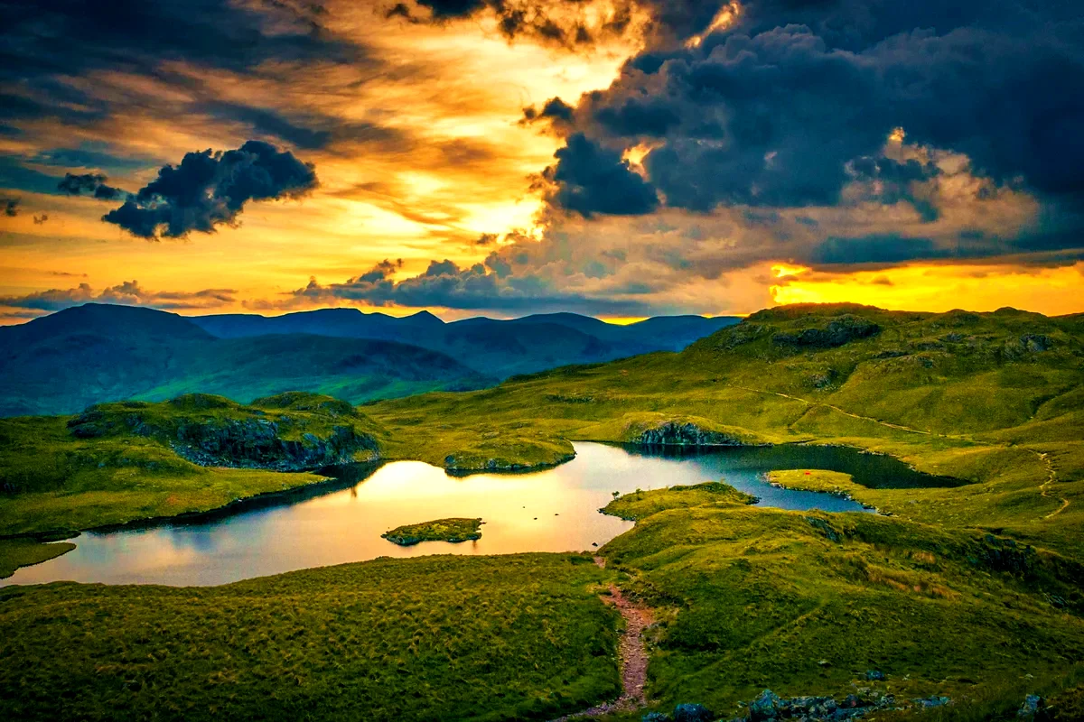 Un piccolo lago tra le colline del Lake District al tramonto